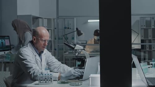 Scientist and Assistant Working in Lab