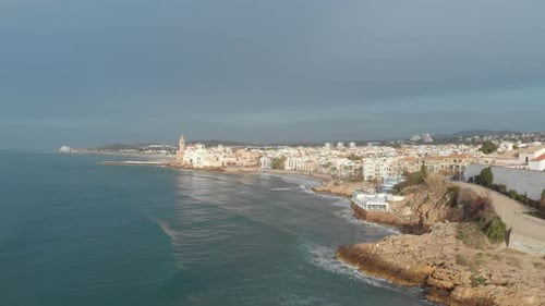 Stunning Drone Footage of Rocky Coastal Landscape with City in Background Captured Early Morning