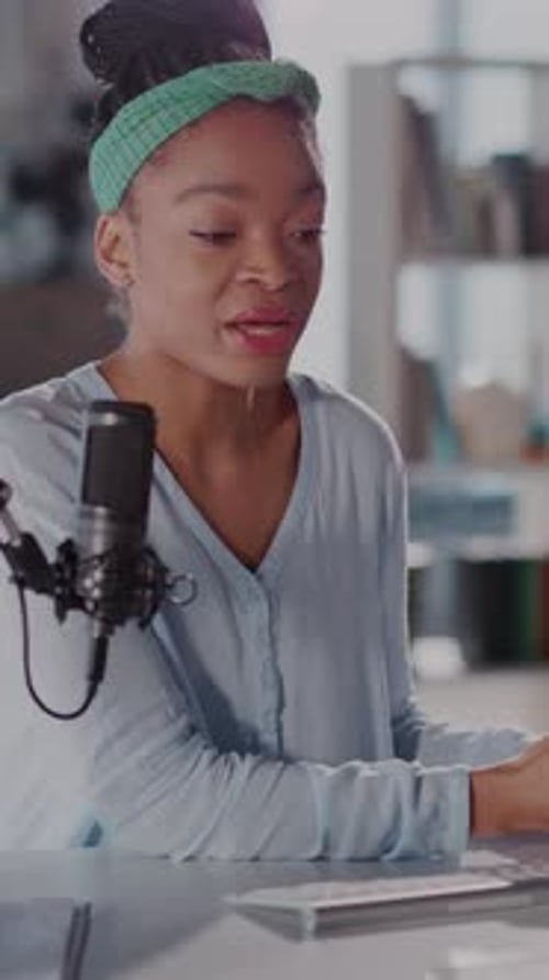 Woman Vlogging at Table With Microphone and Camera