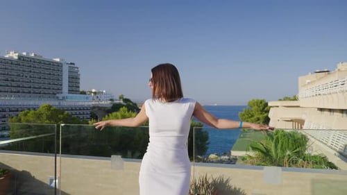 Woman with sunglasses on hotel balcony