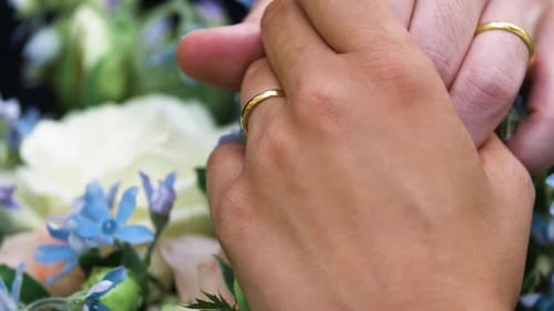 Close slow motion shot of the hands of a married couple with the wedding rings.