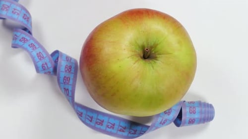 Fresh Apple and Measuring Tape on White Background