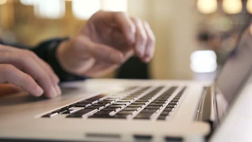 A Businessman Typing His Fingers on the Laptop Keyboard Writes an E-Mail