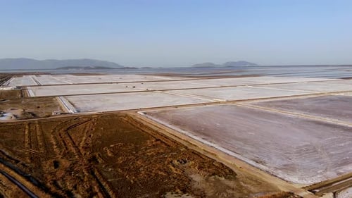 View of a salt flat factory besides the sea - Drone Shot of salt extraction