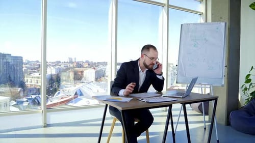Professional entrepreneur working at office centre. Businessman in suit sitting at his workplace