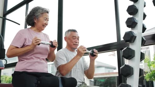 Asian elderly couple workouts together in a fitness center