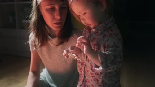 Woman and Child Making Christmas Ornament Together Indoors