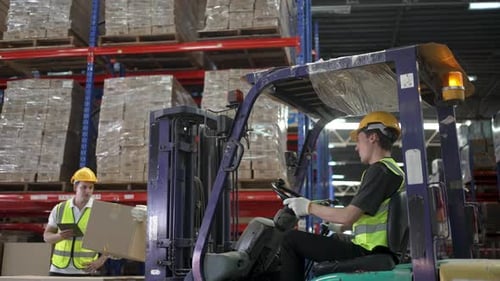 Blue collar workers are working at warehouse.