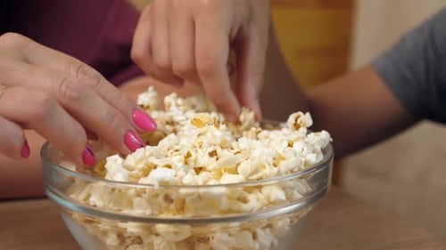 Hands Sharing a Bowl of Tasty Popcorn