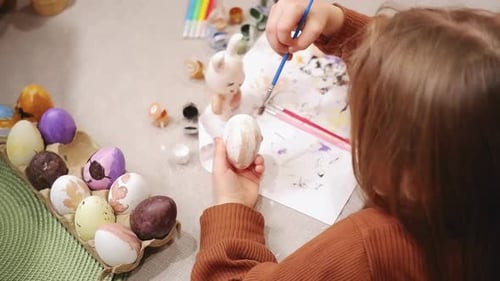 Child Painting Easter Egg at Home