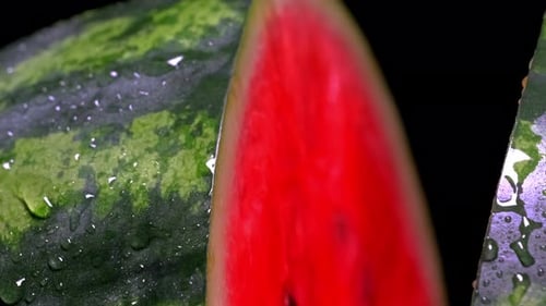 Closeup of a watermelon cut in half being sprayed with water