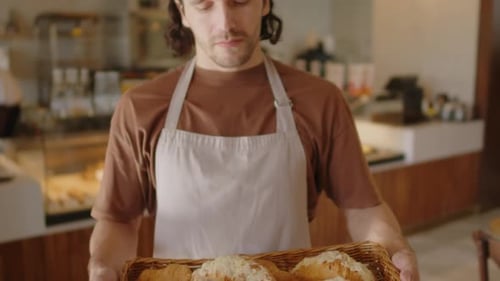 Friendly Baker Holds Tray of Delicious Croissants