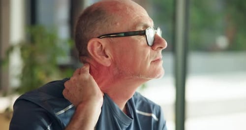 Mature Man Massaging Sore Neck Indoors