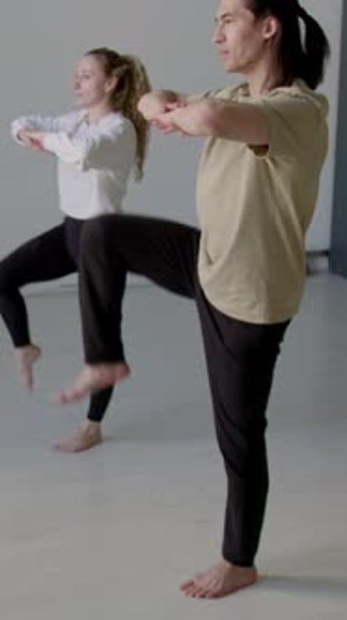 Woman and Man Doing Leg Raise Exercises