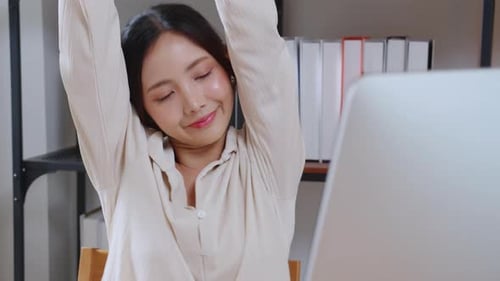 Portrait young asian businesswoman taking a break after overworked with stretching arm and hand.