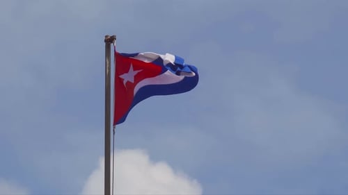 Cuban flag on flagpole waving in wind, copyspace on the right, up to 4K