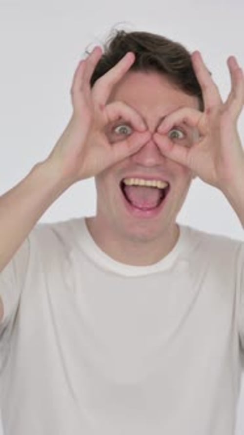 Funny Young Man with Binocular Gesture Searching on White Background, Vertical Video