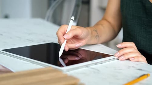 close-up of a woman working with a stylus on a tablet
