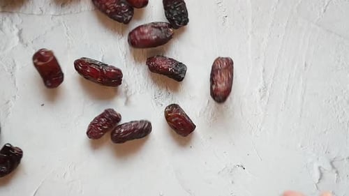 Slow Motion of Date Fruit Dropping on White Background