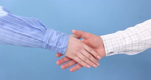 Business Handshake on Blue Background in Studio Lighting