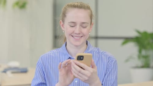 Young Woman Using Smartphone in Office