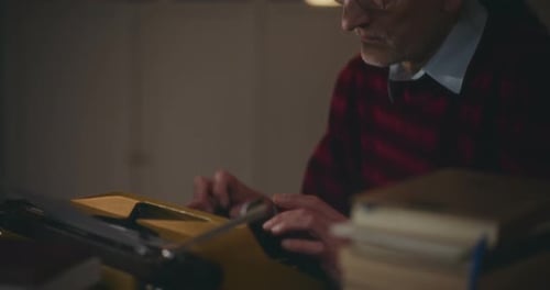 Adult Typing on Vintage Yellow Typewriter Indoors