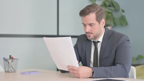 Businessman Cheering After Reading Good Documents