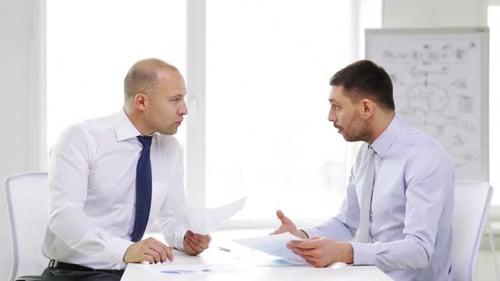 Business, Partnership, Finances and Office Concept - Two Serious Businessmen Holding Papers