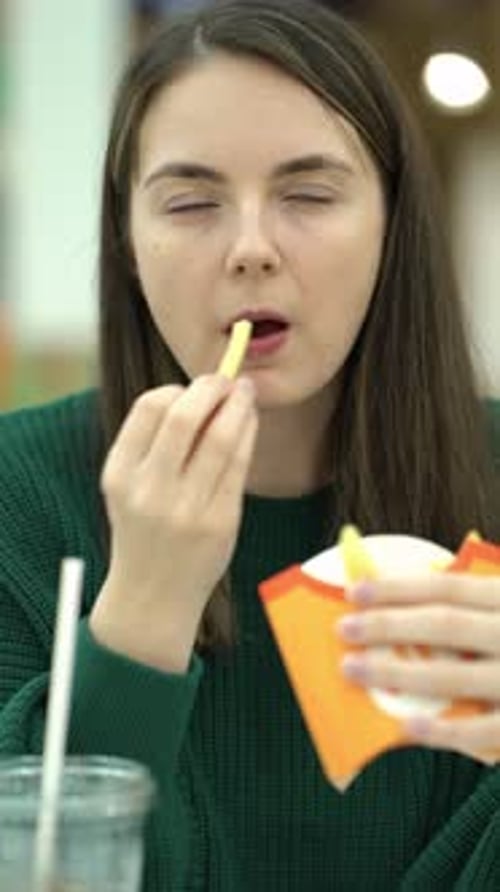 Woman Eating French Fries and Cola at the Food Court