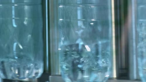 Neue Plastikflaschen auf dem Förderband einer Trinkwasseranlage. Klares Wasser aus einem tiefen Brunnen