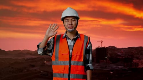 Male Engineer Smiling And Waving Hand Saying Bye at Construction Site, Mining Machinery