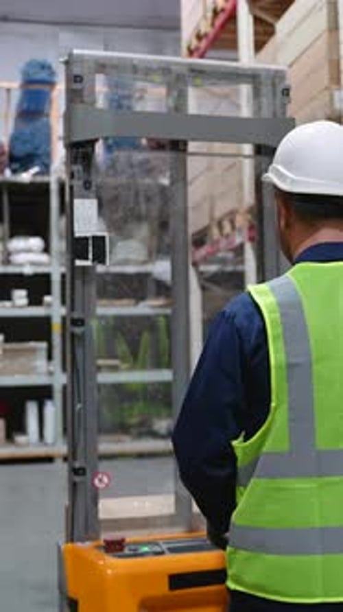 Worker Moving Goods on Forklift at Warehouse