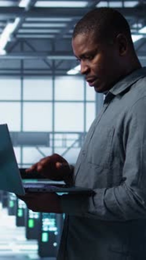 Vertical Video Portrait of Happy System Administrators in Data Center Using Devices