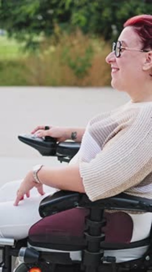 Happy disabled woman enjoying a sunny day in park