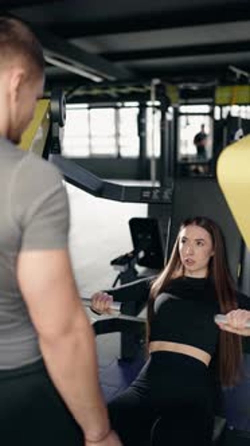 Woman Works Out on Seated Machine at the Gym
