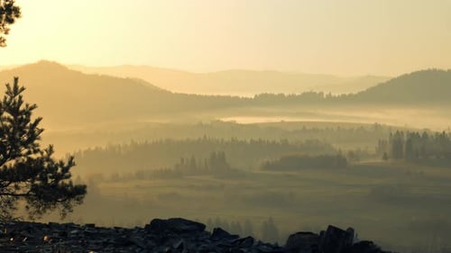Golden Sunrise Illuminates Misty Mountain Valley