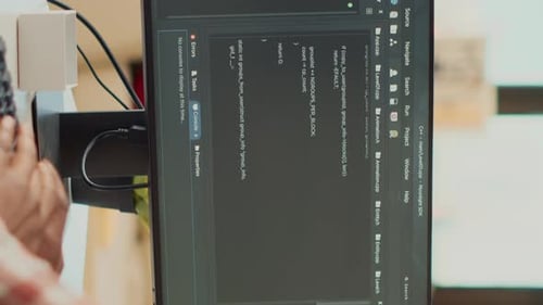 Person Coding at Computer in Home Workspace