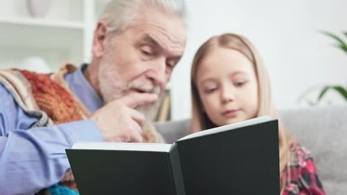 Grandfather and Granddaughter Reading a Book