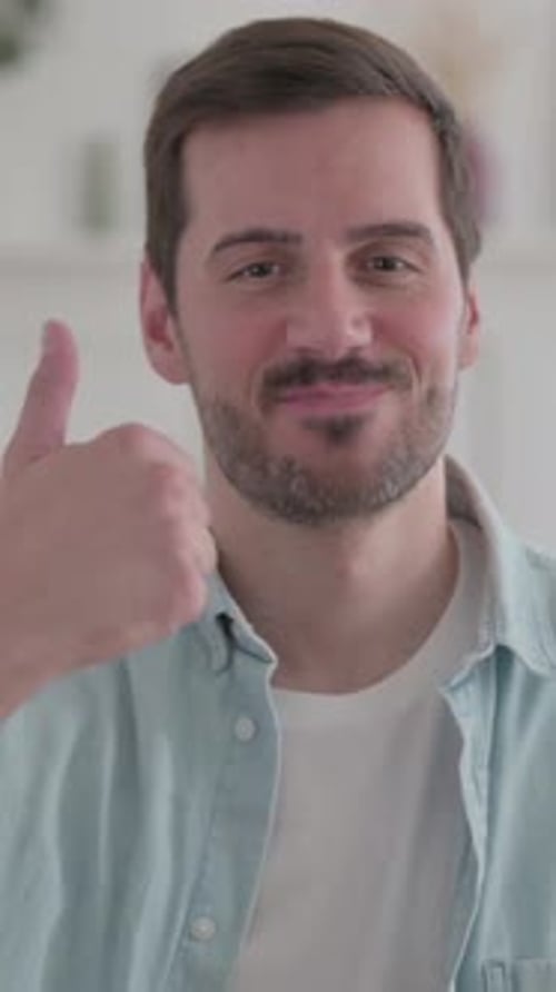 Smiling Man Giving Thumbs Up Indoors in Portrait Orientation
