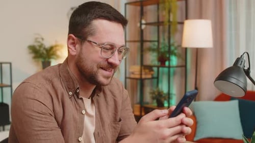 Man Uses Smartphone Inside Apartment