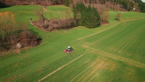 Tractor working on agriculture green field. Combine harvester cultivating field
