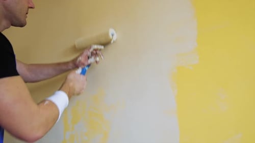 Man Painting Wall With Paint Roller