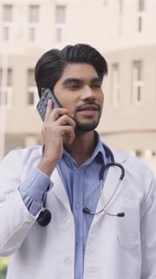 Young Adult Doctor Talking on Cell Phone Outside