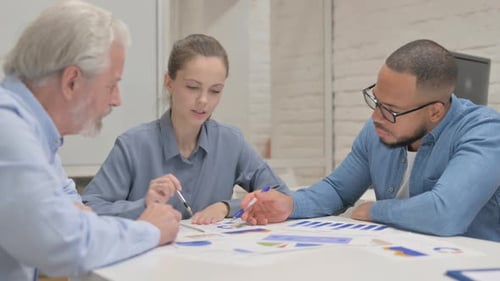 Close up of Female Leader Working on Documents with Teammates