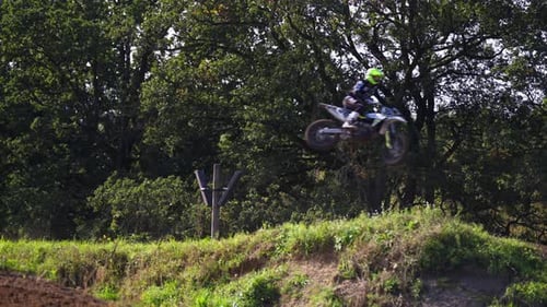 Motocross Riders Jumping Over Hill on Dirt Bikes