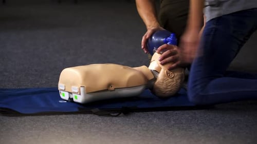 Instructors Demonstrate Rescue Breathing on Medical Mannequin