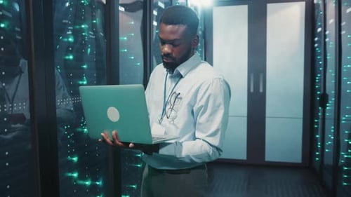 Man Working on Laptop in Data Center