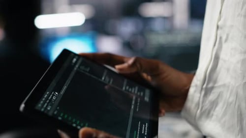 Close Up of Data Center Software Developer Using Tablet to Review Code