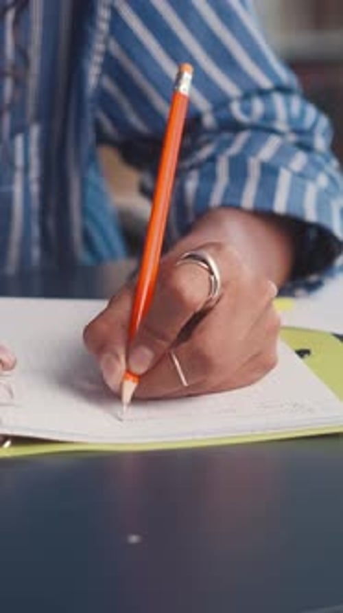Student Practicing NoteTaking Skills With Pencil in Classroom
