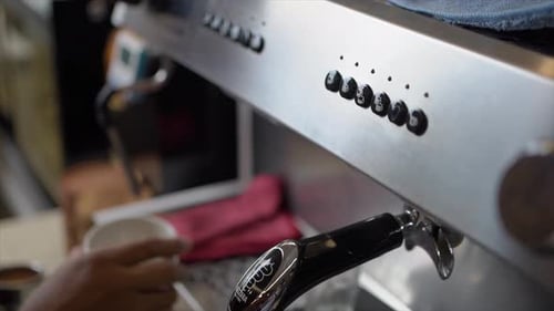 Barista man installs portafilter on coffee machine to make cappuccino or latte. The concept of makin